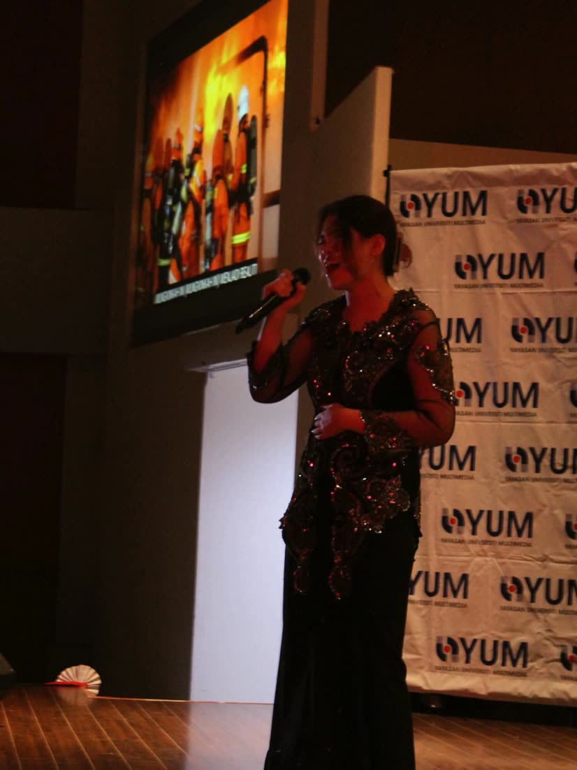 Trisha singing in a black kebaya